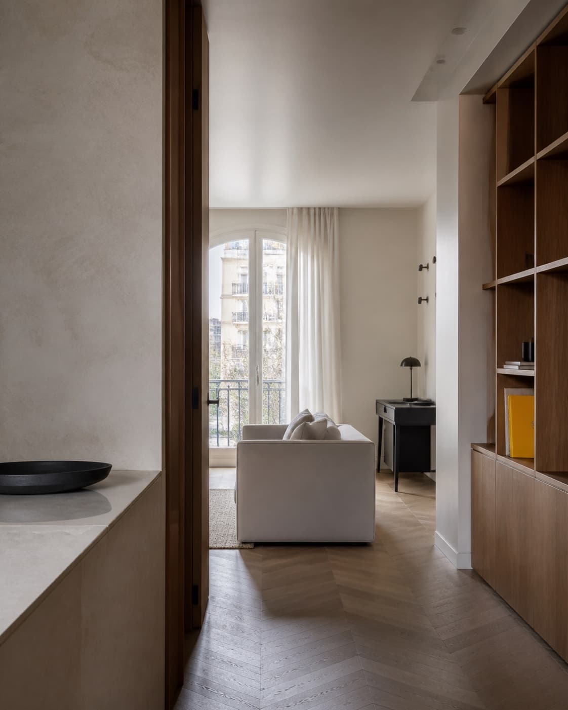 Interior sereno con luz natural, almacenaje integrado y materiales neutros
